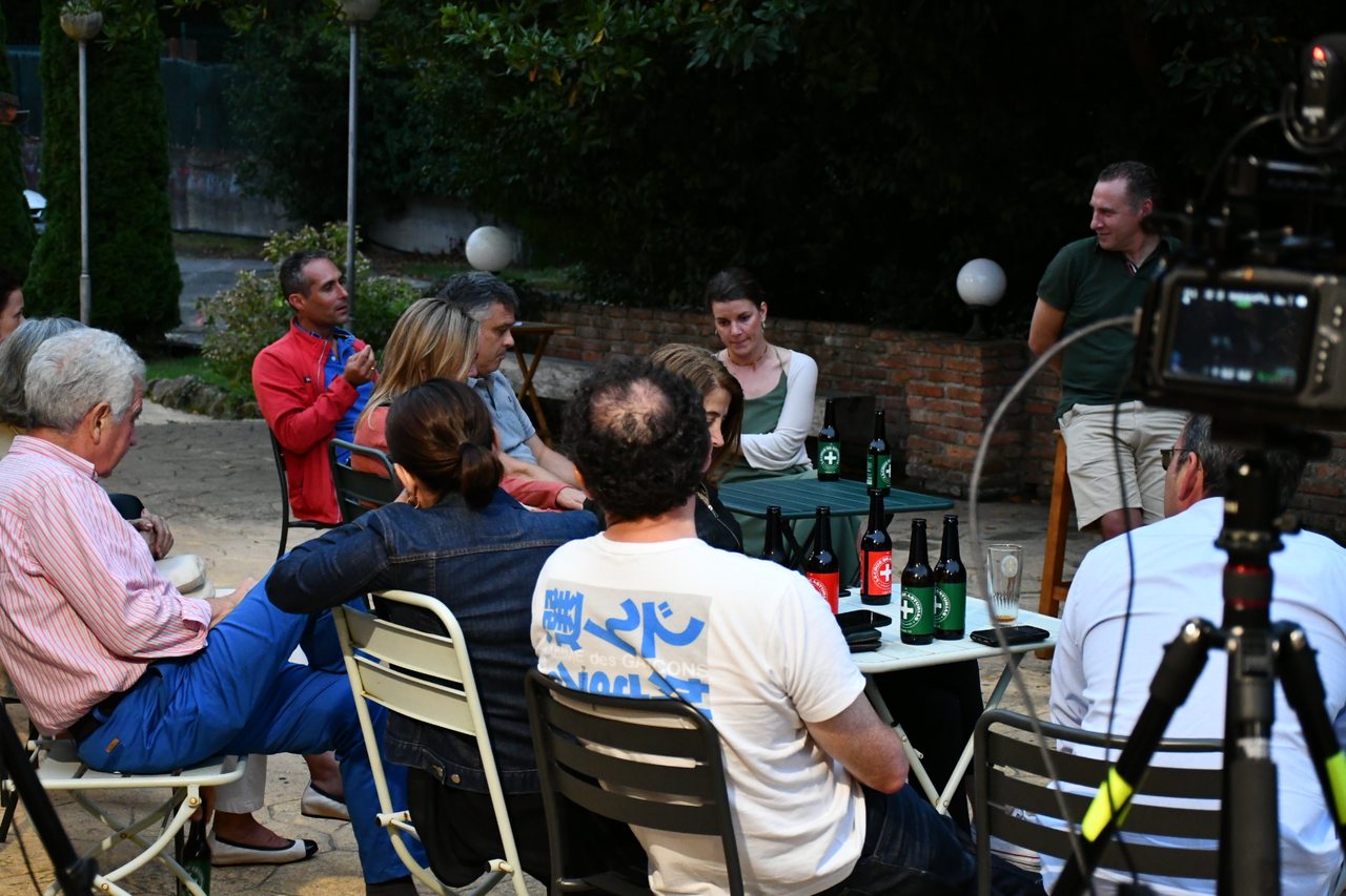 Participants contribute to a roundtable discussion outdoors at Diáspora