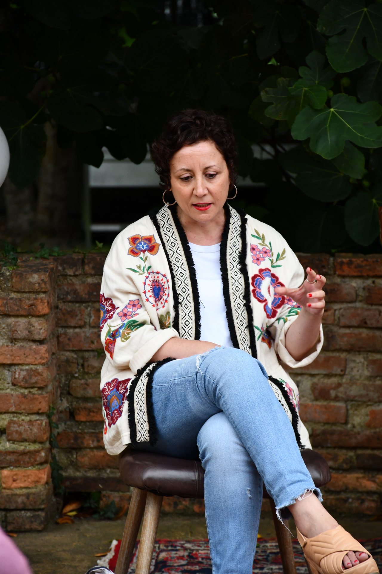 A seated woman gestures while speaking during a Diáspora discussion