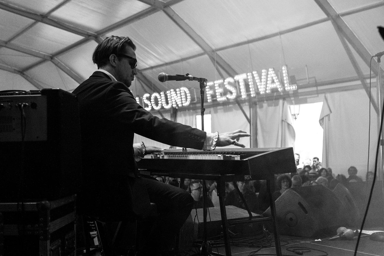 A keyboard player performs with the festival audience beyond the stage