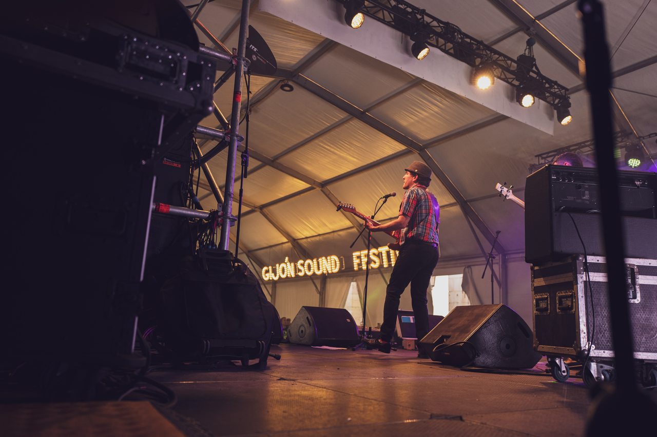 A singer performs under purple stage lights at Gijón Sound Festival