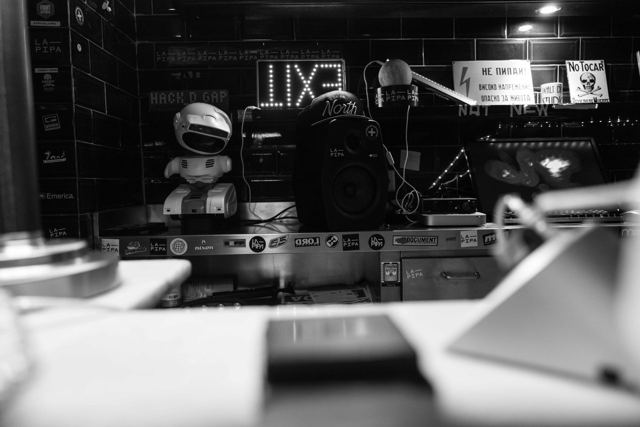 Recording equipment and acoustic panels inside a recording studio, photographed in black and white